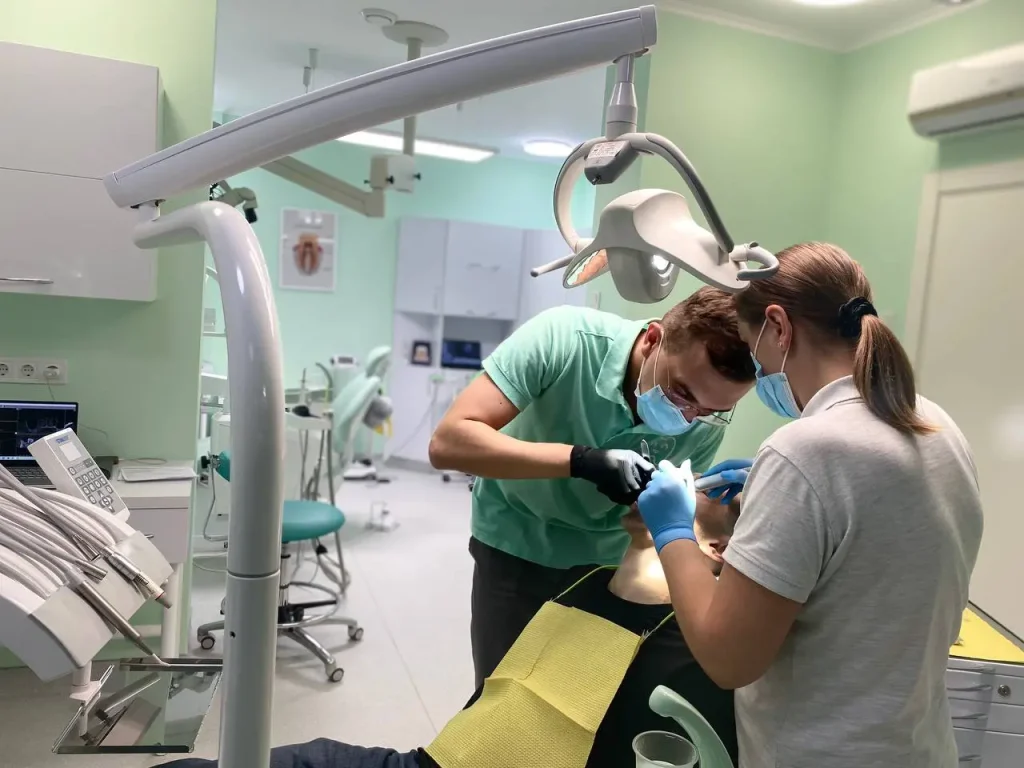 Стоматолог встановлює пломбу пацієнту в сучасному стоматологічному кабінеті